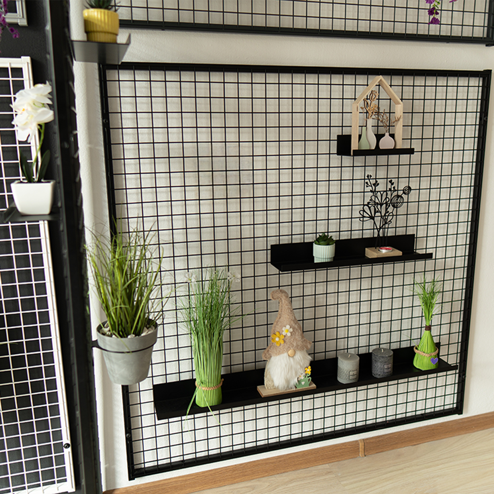 Schwarzes Loft-Gitter mit Pr&auml;sentationsregalen f&uuml;r Dekorationen, Pflanzen und Wohnaccessoires.