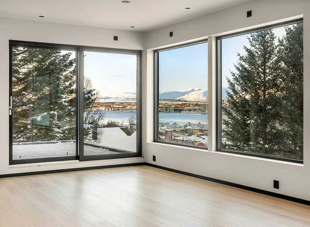 Große anthrazitfarbene Fenster in modernem Raum mit Blick nach draußen – Beispiel für dunkle Fensterrahmen im Innenraum.