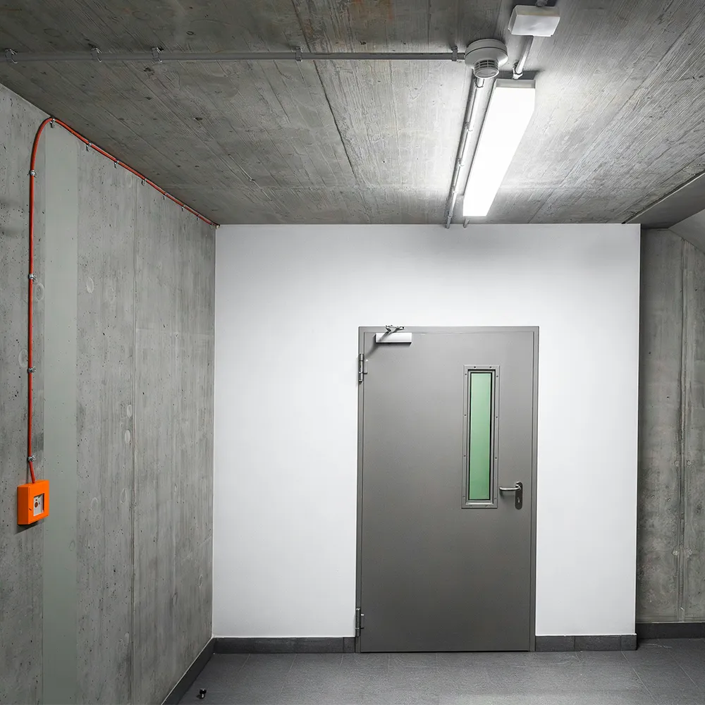 Brandschutzt&uuml;r in einem Technikraum - graue Stahlt&uuml;r in Betonumgebung, eingesetzt zur Begrenzung der Brandausbreitung zwischen Geb&auml;udebereichen.