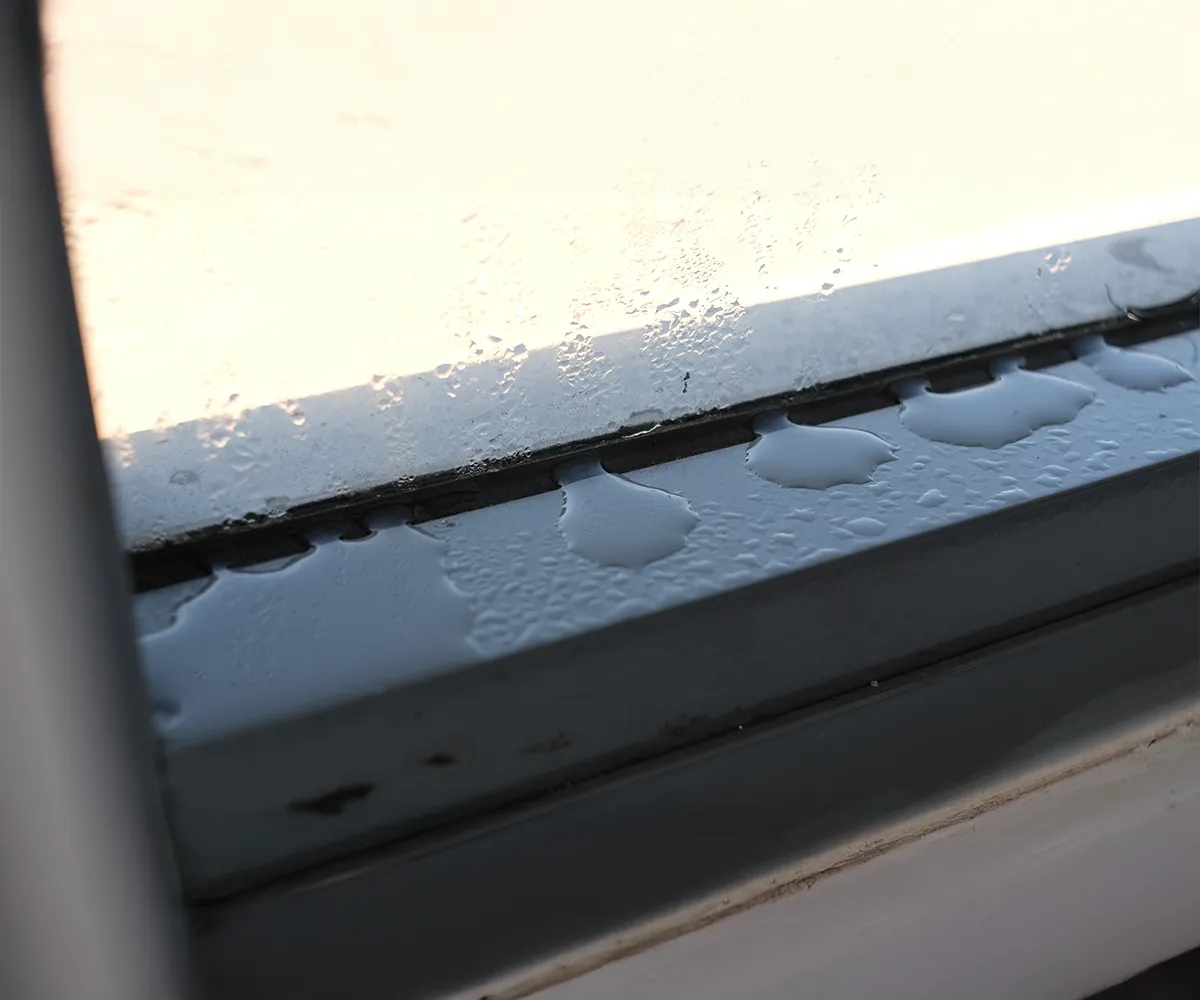 Wassertropfen auf der Au&szlig;enseite einer Fensterscheibe &ndash; Kondensation au&szlig;en als Zeichen guter W&auml;rmed&auml;mmung moderner Fenster.