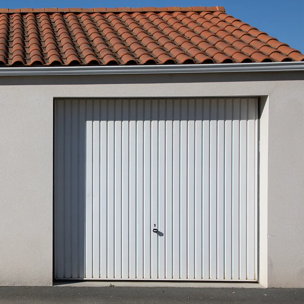 Weißes Garagentor in einer kleinen freistehenden Garage