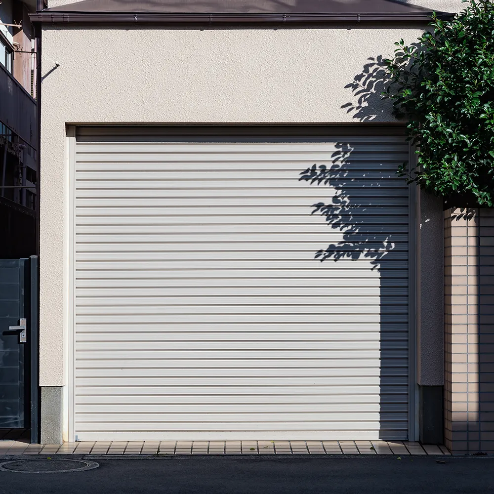 Weißes Rolltor in einer kleinen Garage mit kurzer Einfahrt
