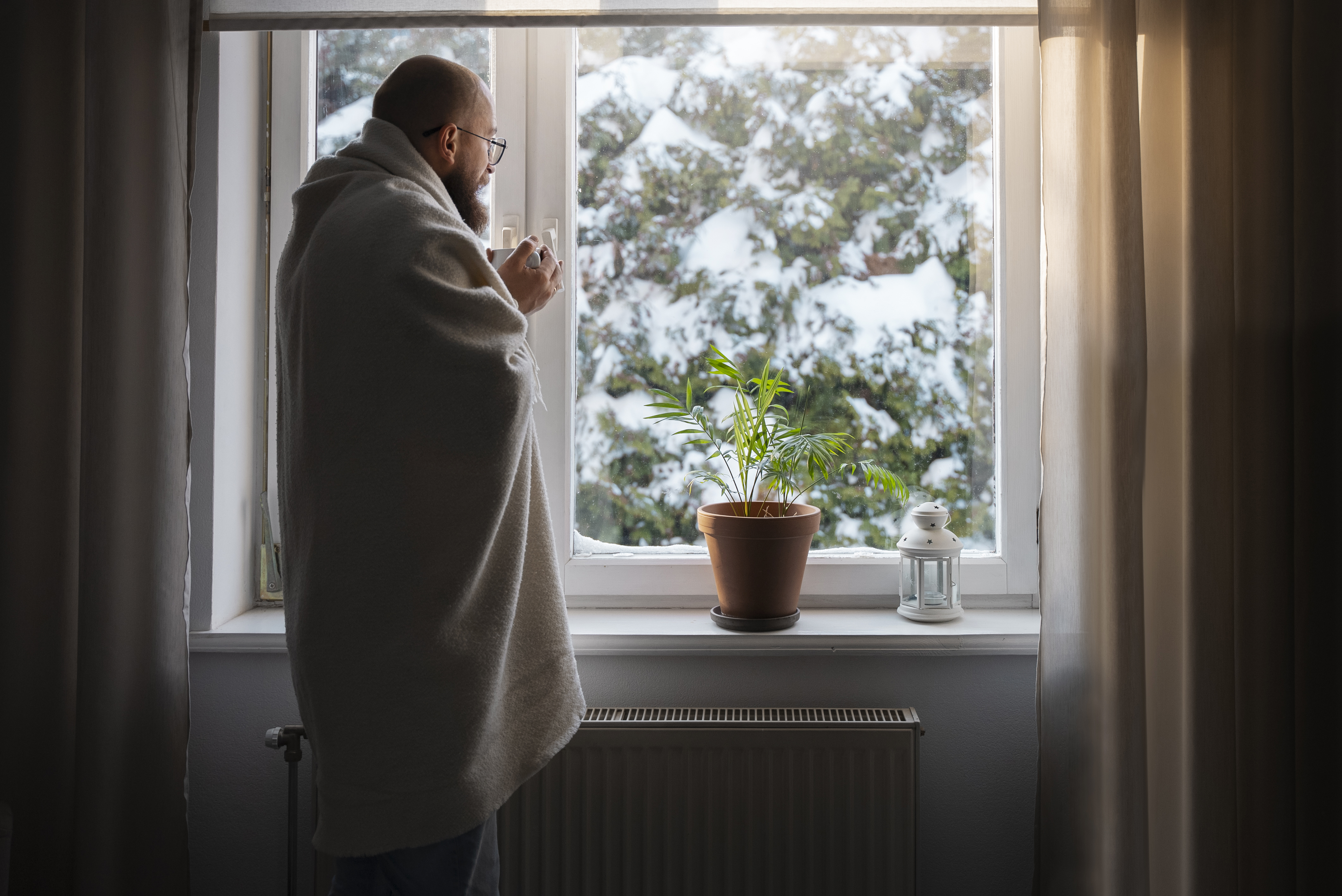 Zwei Handwerker im Dachgeschoss messen und pr&uuml;fen die D&auml;mmung unter einem Dachfenster &ndash; energetische Dachisolierung zur Reduzierung von W&auml;rmeverlusten